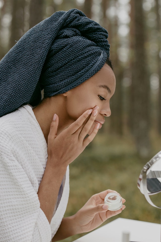 woman putting acne medication on face